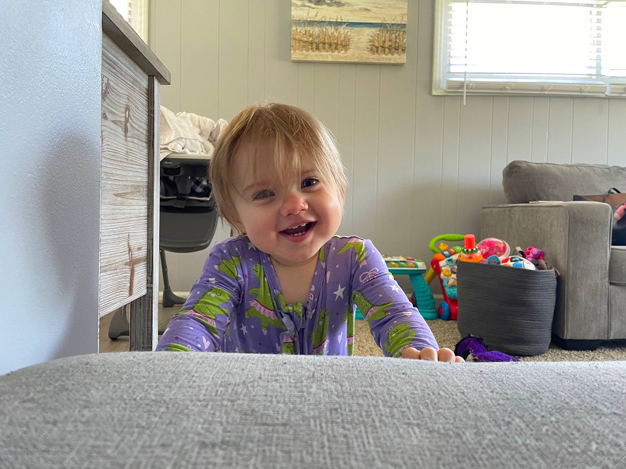 Lilyana is registered to the contest to win money with this photo: baby, child, comfort, couch, flooring, fun, happy, home, joy, living_room, person, picture_frame, play, room, sitting, smile, studio_couch, t_shirt, toddler, window