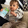Kaylan a rejoint le concours — aidez-le/la à gagner de superbes lots ! baby, blanket, blue_eyes, bokeh, child, comfort, couch, expressive, hands, hoodie, indoor, messy_hair, mickey_mouse, onesie, portrait, sitting, snack, soft_lighting, squeeze_pouch, toddler