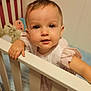 toddler, crib, child, baby, indoor, nursery, toy, soft_toy, railing, curious, person, face, portrait, pink, white, blue, clothing, cute, hand, exploration
