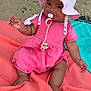 baby, beach, casual, child, cute, happy, infant, outdoor, pacifier, pink_dress, portrait, relaxation, rock, sand, sitting, small_child, summer, sun_hat, sunlight, towel