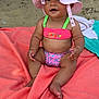 baby, barefoot, beach, child, colorful, cute, hat, infant, outdoor, pink, playful, portrait, sand, sitting, smiling, summer, sunhat, swimsuit, towel, vacation