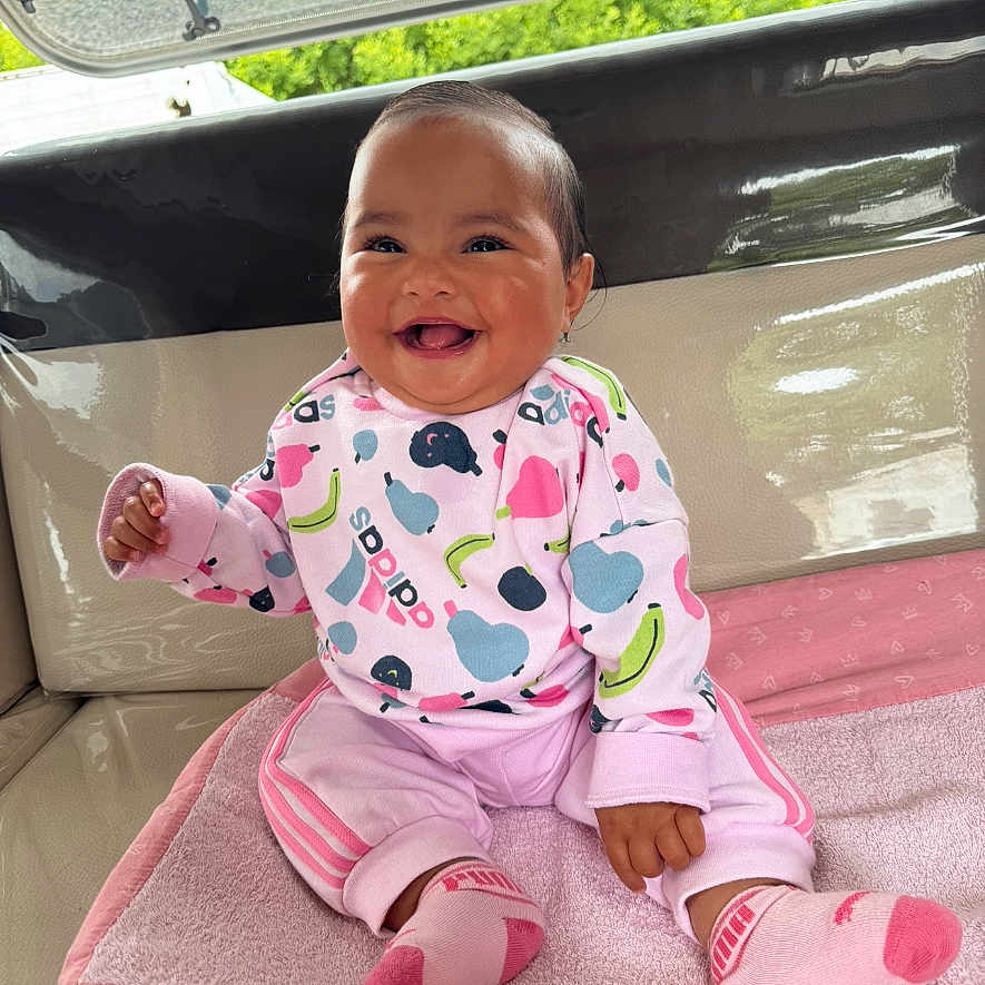 Matahina participe au concours pour gagner de l'argent avec cette photo : adorable, apparel, baby, blanket, casual_wear, child, comfort, cute, face, happy, hooded_jacket, indoor, infant, person, pink_clothing, playful, sitting, smiling, socks, soft_texture