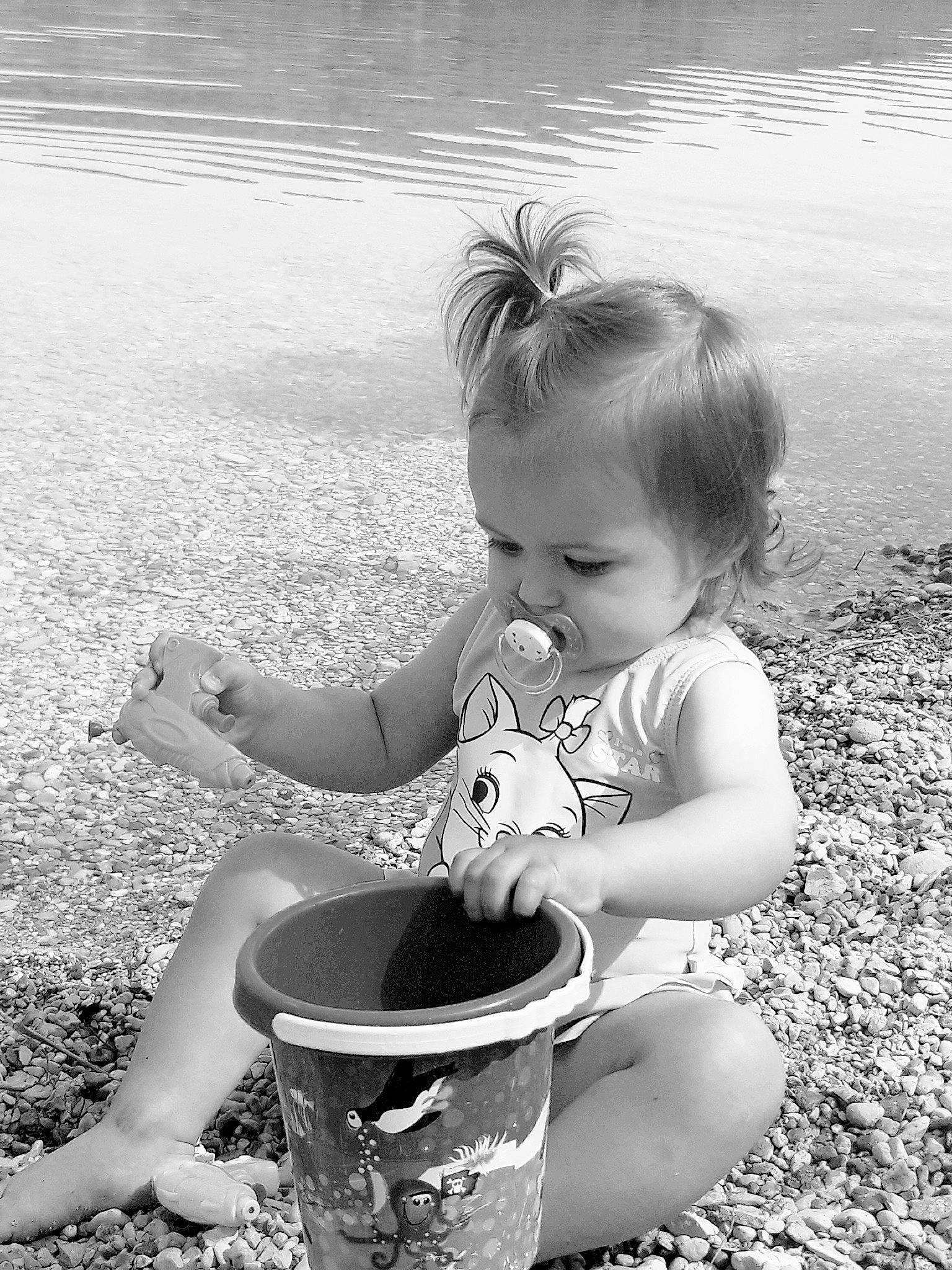 Alyanna a rejoint le concours — aidez-le/la à gagner de superbes lots ! arm, black, black_and_white, bucket, child, flash_photography, fun, grass, hand, happy, monochrome, monochrome_photography, people_in_nature, person, photograph, standing, style, summer, toddler, water