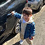 Devrane participe au concours pour gagner de l'argent avec cette photo : child, toddler, car, toy_cars, denim_jacket, hoodie, sneakers, sidewalk, street, shadow, daylight, outdoor, vehicle, curb, urban, person, expression, holding, door_handle, casual_clothing