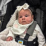 baby, child, stroller, blanket, headband, bow, face, clothing, straps, magnetic_buckle, white, pink, knitted, infant, person, cute, indoors, portrait, seated, baby_bib
