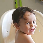 Malcolm is registered to the contest to win money with this photo: baby, bare_torso, candid, cheeky, child, curly_hair, eyes, face, grin, highchair, home, indoor, mouth, playroom, plush_toy, portrait, seat, smile, toddler, toy