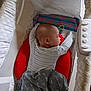 baby, sleeping, bassinet, blanket, pillow, toy, infant, sleep, cozy, resting, child, bed, fabric, comfort, indoor, person, peaceful, soft_lighting, striped_clothing, blanket_pattern