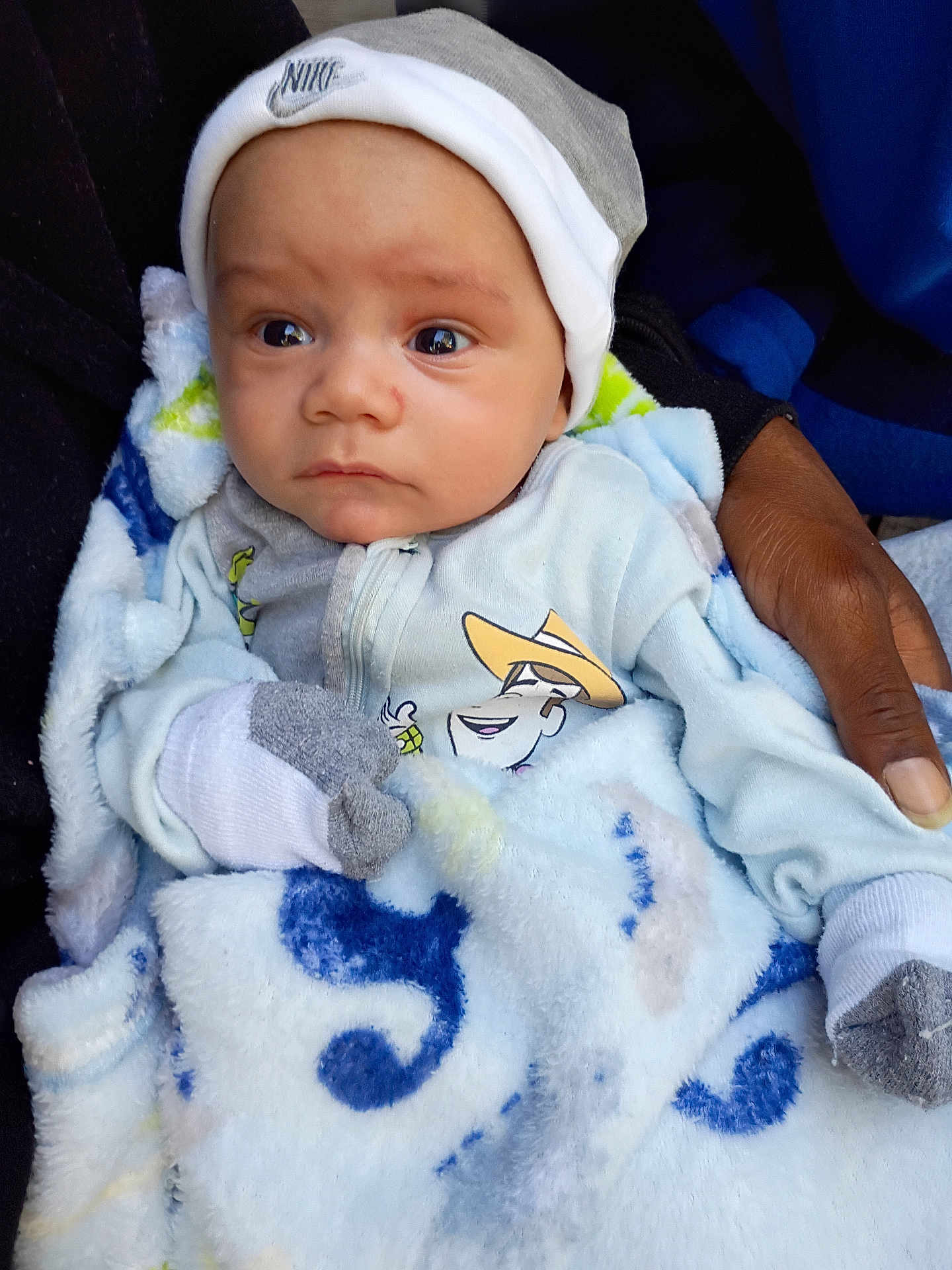 Avalon is registered to the contest to win money with this photo: baby, infant, blanket, mittens, hat, clothing, hand, person, portrait, face, eyes, warm, cozy, blue, white, pattern, soft, newborn, cute, snug