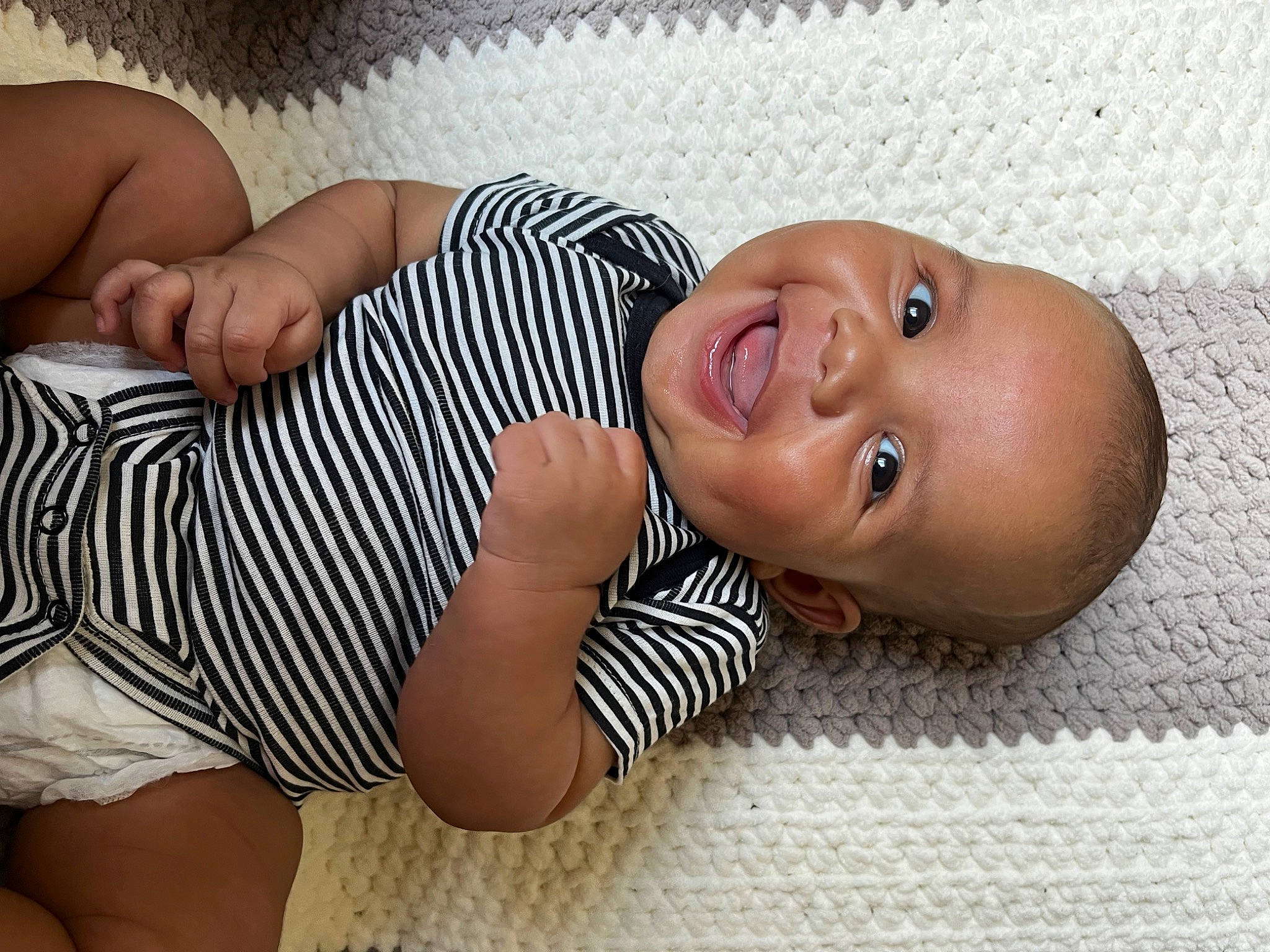 Arden is registered to the contest to win money with this photo: arm, baby, baby_toddler_clothing, cheek, child, comfort, eyelash, facial_expression, finger, flooring, happy, leg, linens, mouth, nose, person, skin, sleeve, smile, toddler