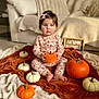 baby, toddler, child, pumpkin, orange, white_pumpkin, blanket, autumn, seasonal, cozy, indoor, floor, sign, clothing, pink_bow, sitting, cute, face, person, home