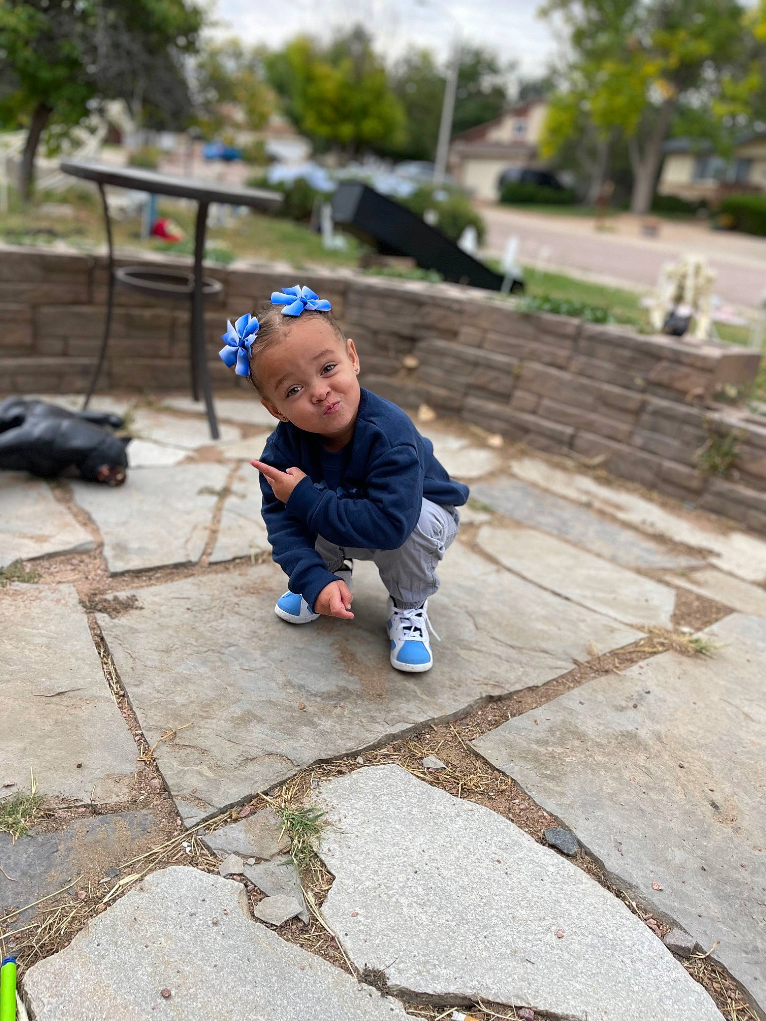 Amora is registered to the contest to win money with this photo: asphalt, baby, child, city, cobblestone, flooring, fun, grass, leaf, leisure, mammal, person, plant, recreation, road_surface, sidewalk, sitting, sky, toddler, tree