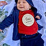 baby, infant, smiling, clothing, jacket, pants, red_shirt, wooden_plaque, two_months, blanket, patterned_blanket, lying_down, happy, cute, face, hand, headwear, cozy, child, portrait