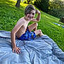 blanket, blue_shorts, boy, bracelets, casual, child, grass, happy, lake, nature, outdoor, park, posing, recreation, shirtless, shorts, smiling, summer, sunlight, trees