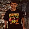 boy, child, smiling, tshirt, spongebob, brick_wall, outdoor, greenery, casual, portrait, young, person, short_hair, sitting, happy, background, year, 2026, clothing, leaves