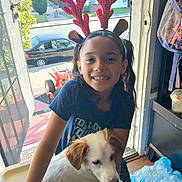 Michaela joined the competition — help win amazing prizes! child, girl, puppy, dog, reindeer_antlers, smiling, indoors, doorway, sunlight, backpack, bottled_water, wooden_floor, neighborhood, car, tree, toy, happy, pet, casual_clothing, home