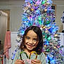 Vanessa is registered to the contest to win money with this photo: candy_cane, celebration, cheerful, child, christmas_tree, decorations, festive, fun, girl, happy, holding, holiday, home, indoors, joy, lights, portrait, seasonal, smiling, winter