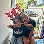 child, children, smiling, peace_sign, reindeer_antlers, headband, indoor, doorway, bench, casual_clothing, happy, sitting, portrait, two_people, daylight, window, street, car, trees, neighborhood