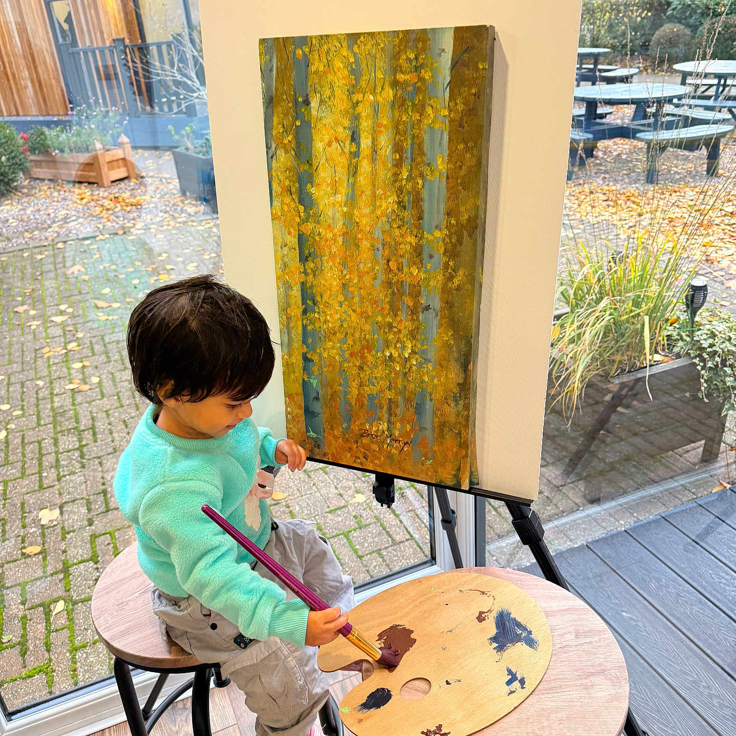Alfia joined the competition — help win amazing prizes! art, autumn, canvas, casual, child, clothing, creative, easel, floor, focused, garden, indoors, leaves, paintbrush, painting, palette, person, stool, window, young_child