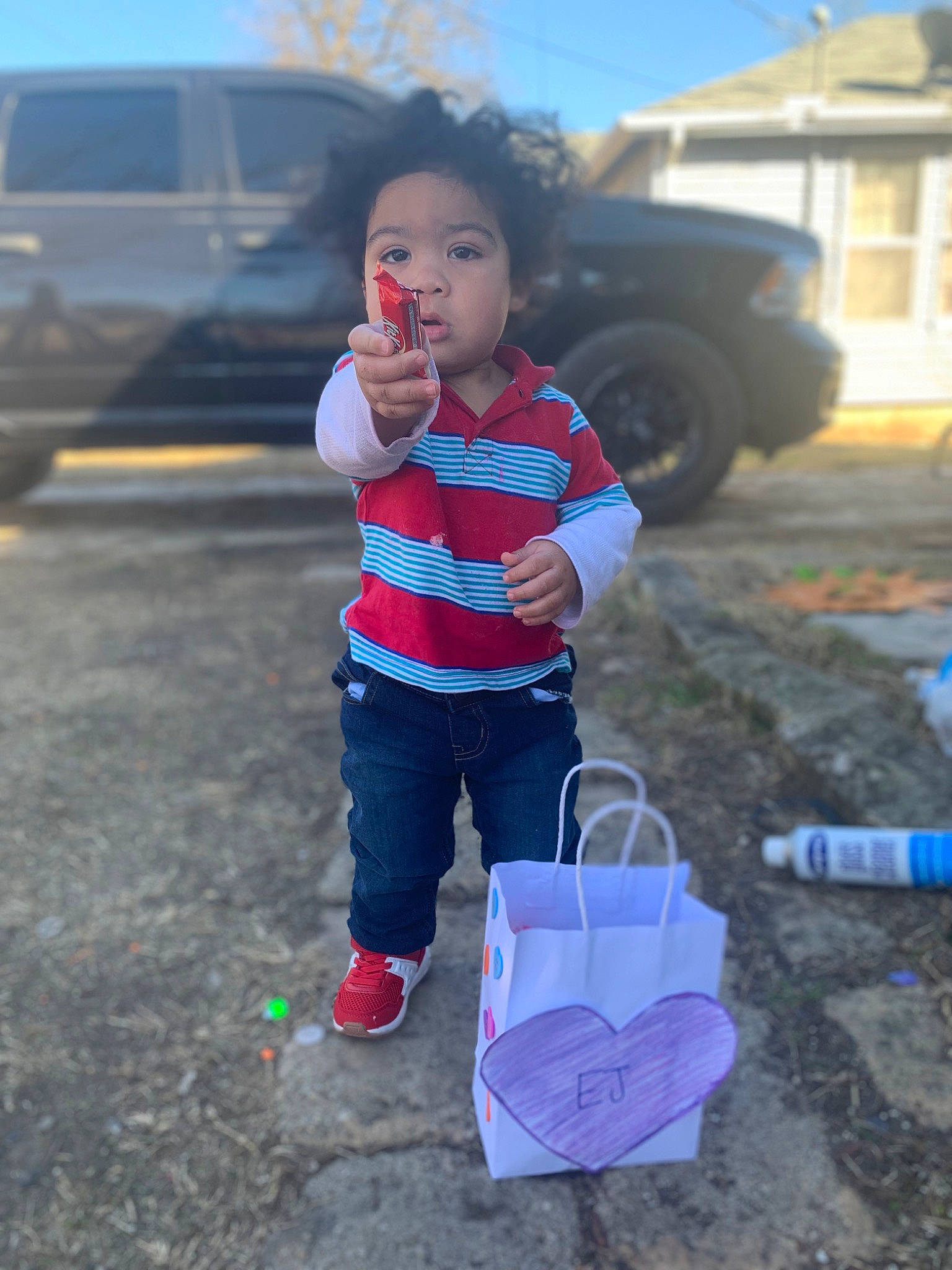 Emanuel is registered to the contest to win money with this photo: asphalt, automotive_tire, car, child, family_car, fun, grass, morning, person, plant, play, public_space, recreation, shorts, sky, soil, t_shirt, tire, toddler, vehicle_door