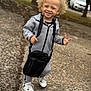 blonde_hair, casual_wear, child, crossbody_bag, curly_hair, daylight, fashion, happy, nike, outdoor, pavement, person, smiling, standing, street, toddler, tracksuit, urban, white_sneakers, young_child