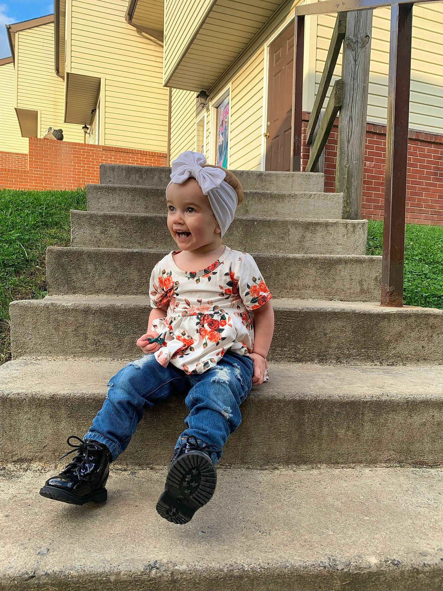 Aurora is registered to the contest to win money with this photo: baby_toddler_clothing, cap, child, denim, fun, grass, happy, hat, head, headwear, landscape, leaf, leisure, person, plant, public_space, smile, stairs, t_shirt, tints_and_shades