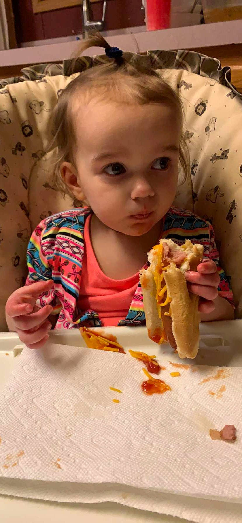 Aurora is registered to the contest to win money with this photo: baby_toddler_clothing, baked_goods, biting, child, comfort_food, cuisine, dish, fast_food, finger_food, food, food_craving, fun, ingredient, junk_food, person, sharing, staple_food, sweetness, table, tableware