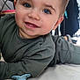Nino a rejoint le concours — aidez-le/la à gagner de superbes lots ! baby, bodypart, clothing, coat, face, finger, furniture, hand, happy, head, indoors, jacket, mouth, pants, person, photography, portrait, sitting, smile, teeth