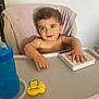 Nino participe au concours pour gagner de l'argent avec cette photo : baby, bathing, bodypart, chair, cushion, electronics, face, finger, furniture, hand, head, homedecor, indoors, person, phone, photography, portrait, sitting, table, text