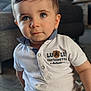 architecture, boy, building, child, clothing, couch, face, furniture, head, indoors, jeans, male, pants, person, photography, portrait, shirt, shorts, sitting, t_shirt