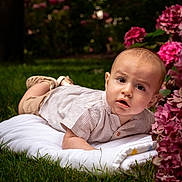 Sohan participe au concours pour gagner de l'argent avec cette photo : baby, child, infant, blanket, grass, flowers, outdoor, nature, portrait, curious, cute, garden, greenery, pink_flowers, clothing, shorts, shoes, face, skin, lying_down
