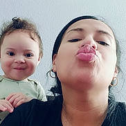 Agnes is registered to the contest to win money with this photo: child, woman, toddler, selfie, face, smile, pout, earrings, black_shirt, curly_hair, long_hair, indoor, wall, portrait, playful, happy, person, casual, light, expression