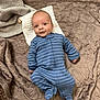 baby, infant, blue_onesie, striped_clothing, blanket, white_cloth, carpet, floor, smile, face, head, lying_down, soft_texture, cozy, indoor, child, cute, young, portrait, baby_clothes