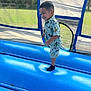 blue, boy, child, clothing, daylight, fun, grass, happy, inflatable, joy, mickey_mouse, outdoor, park, play, shirt, shorts, smiling, socks, toddler, trampoline