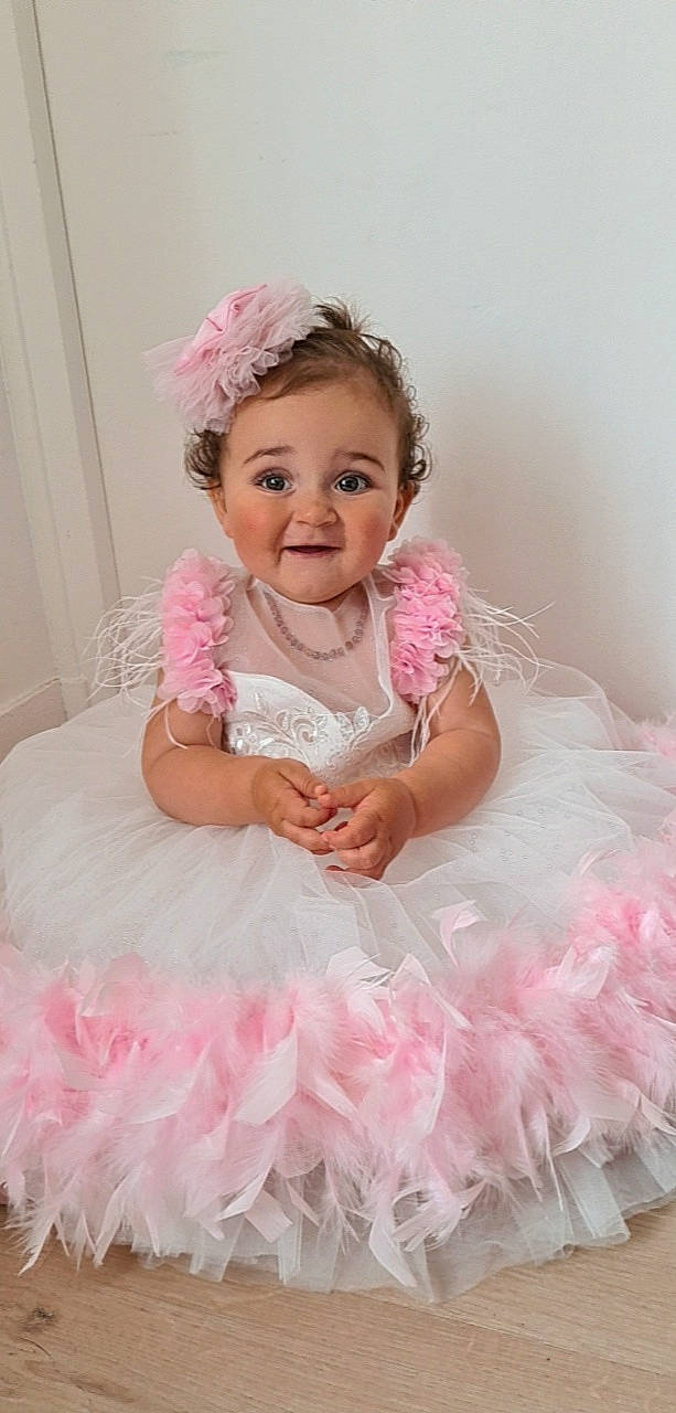 Mila a rejoint le concours — aidez-le/la à gagner de superbes lots ! baby_toddler_clothing, bridal_accessory, bridal_clothing, child, clothing, dress, embellishment, fashion, flash_photography, happy, headpiece, joy, magenta, person, petal, pink, product, skin, sleeve, smile