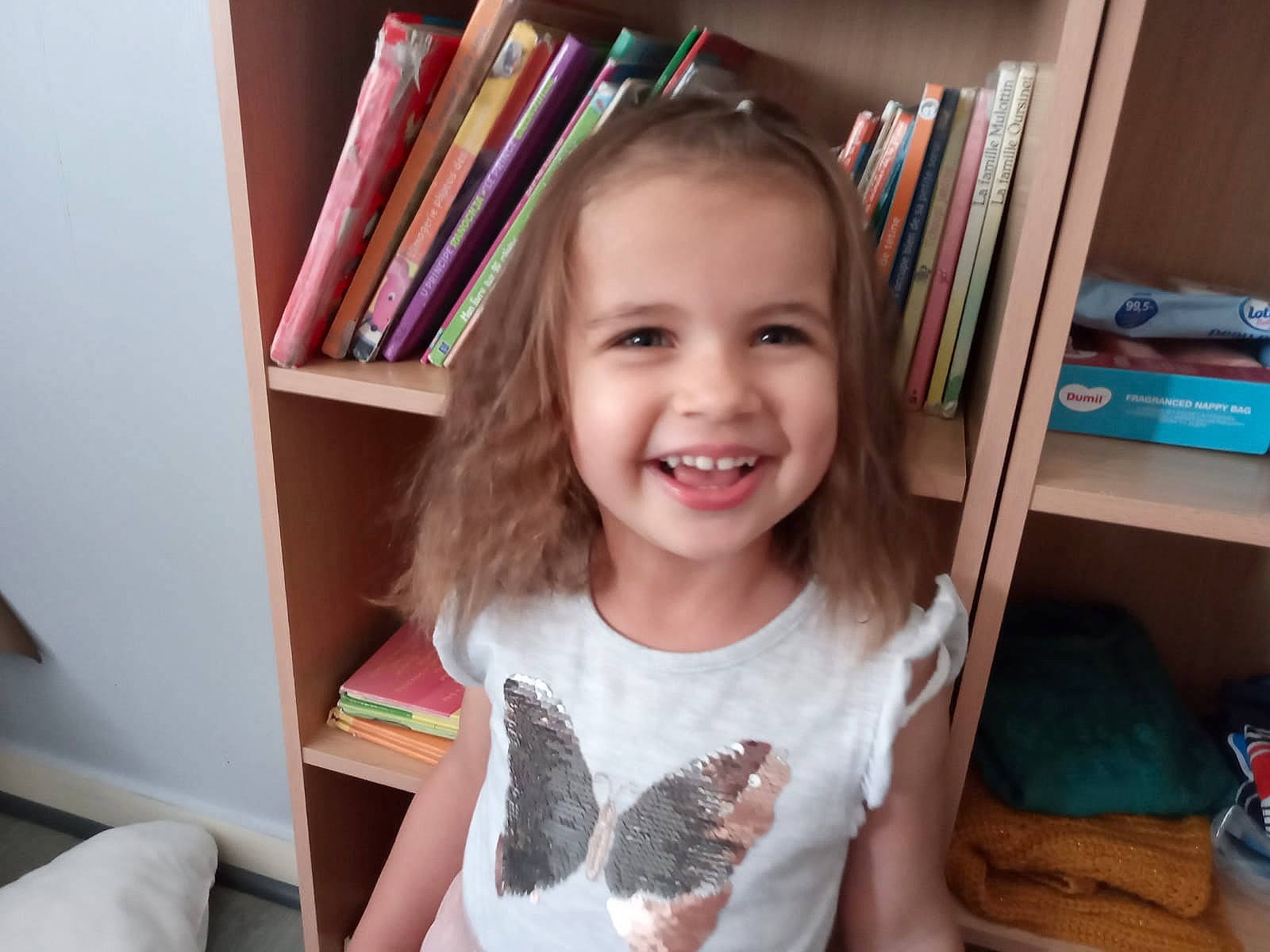 Zélia a rejoint le concours — aidez-le/la à gagner de superbes lots ! book, bookcase, cheek, child, child_art, drawer, eye, fun, happy, iris, joy, person, play, publication, room, shelf, shelving, smile, t_shirt, tin_can