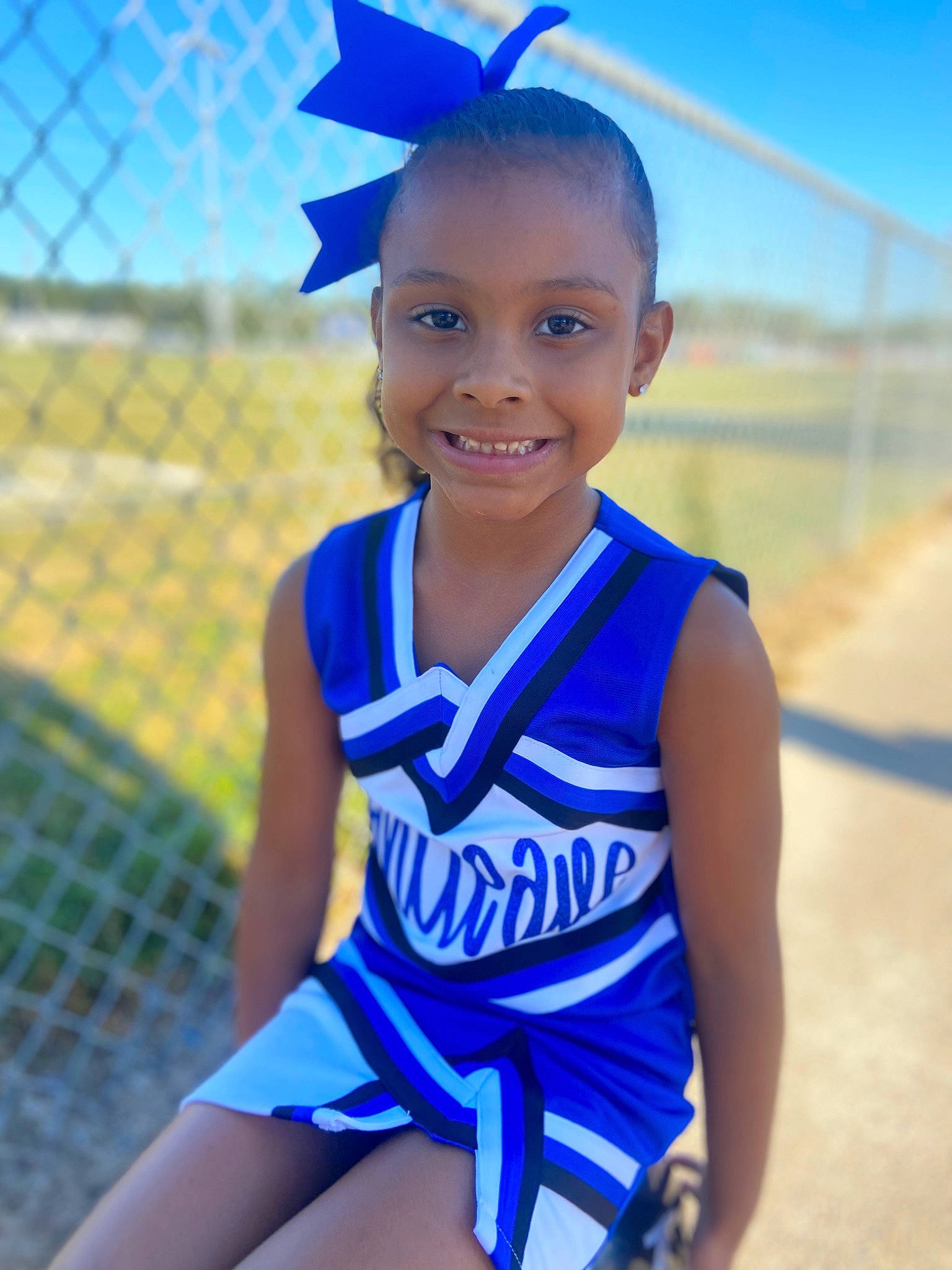 Aniah is registered to the contest to win money with this photo: azure, blue, cheerleading_uniform, electric_blue, eye, face, fence, hair, happy, head, jersey, joy, mesh, person, photograph, player, smile, sports_uniform, sportswear, thigh