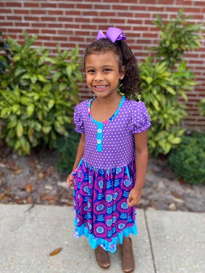 Aniah is registered to the contest to win money with this photo: baby_toddler_clothing, day_dress, dress, electric_blue, eye, face, grass, hair, happy, head, headgear, joy, person, pink, plant, purple, sleeve, smile, street_fashion, summer