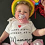 baby, infant, pacifier, birthday, celebration, pink, skirt, bow, smile, face, clothing, inflatable, halo, decorations, red, white_shirt, cute, child, happy, lying_down