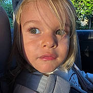 Elio participe au concours pour gagner de l'argent avec cette photo : child, face, green_eyes, car_seat, seatbelt, blond_hair, sunlight, portrait, closeup, outdoor, nature, vehicle_interior, clothing, young_child, curious_expression, daylight, casual, person, seatbelt_strap, hair