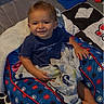 baby, blanket, blue, child, comfort, cushion, face, foot, hand, happy, home, indoor, pattern, person, quilt, seated, shirt, smile, toddler, toy