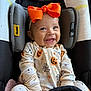 Dolly is registered to the contest to win money with this photo: baby, child, smiling, car_seat, orange_bow, onesie, halloween, pumpkin, ghost, spider_web, cute, infant, clothing, seat_belt, headwear, happy, indoors, portrait, young_child, person