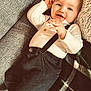 baby, child, smiling, face, clothing, white_shirt, suspenders, couch, blanket, plaid, cozy, happy, indoor, portrait, cute, infant, young_child, relaxing, hands, head