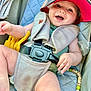 baby, child, smiling, cap, car_seat, seatbelt, blanket, pacifier, toy, clothing, cute, happy, infant, sitting, indoors, face, hand, foot, accessory, comfort