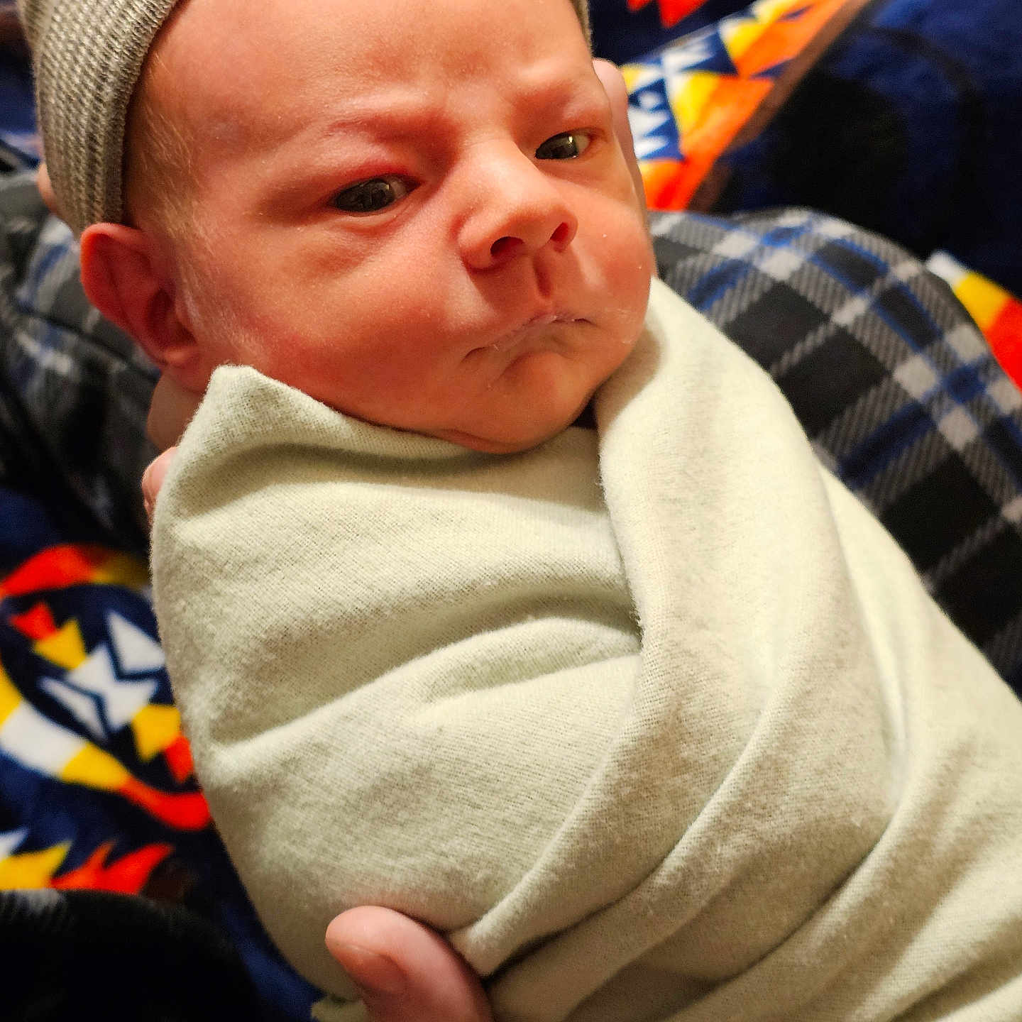 Keaton is registered to the contest to win money with this photo: baby, beanie, blanket, bodypart, bonnet, cap, clothing, face, finger, fleece, frown, hand, hat, head, knitwear, newborn, person, photography, portrait, sweater