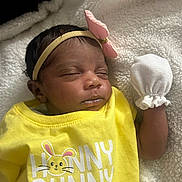 Kyla is registered to the contest to win money with this photo: newborn, baby, infant, sleeping, portrait, face, headband, bow, pink_bow, yellow_clothing, bunny_outfit, mitten, blanket, soft_blanket, closeup, indoors, lying_down, cute, child, text_on_clothing