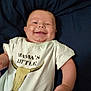 Michael joined the competition — help win amazing prizes! baby, smiling, infant, white_shirt, graphic_tee, cowboy, lying_down, blue_blanket, chubby_cheeks, cute, happy, child, portrait, human, skin, short_hair, casual_clothing, indoors, one_person, toddler