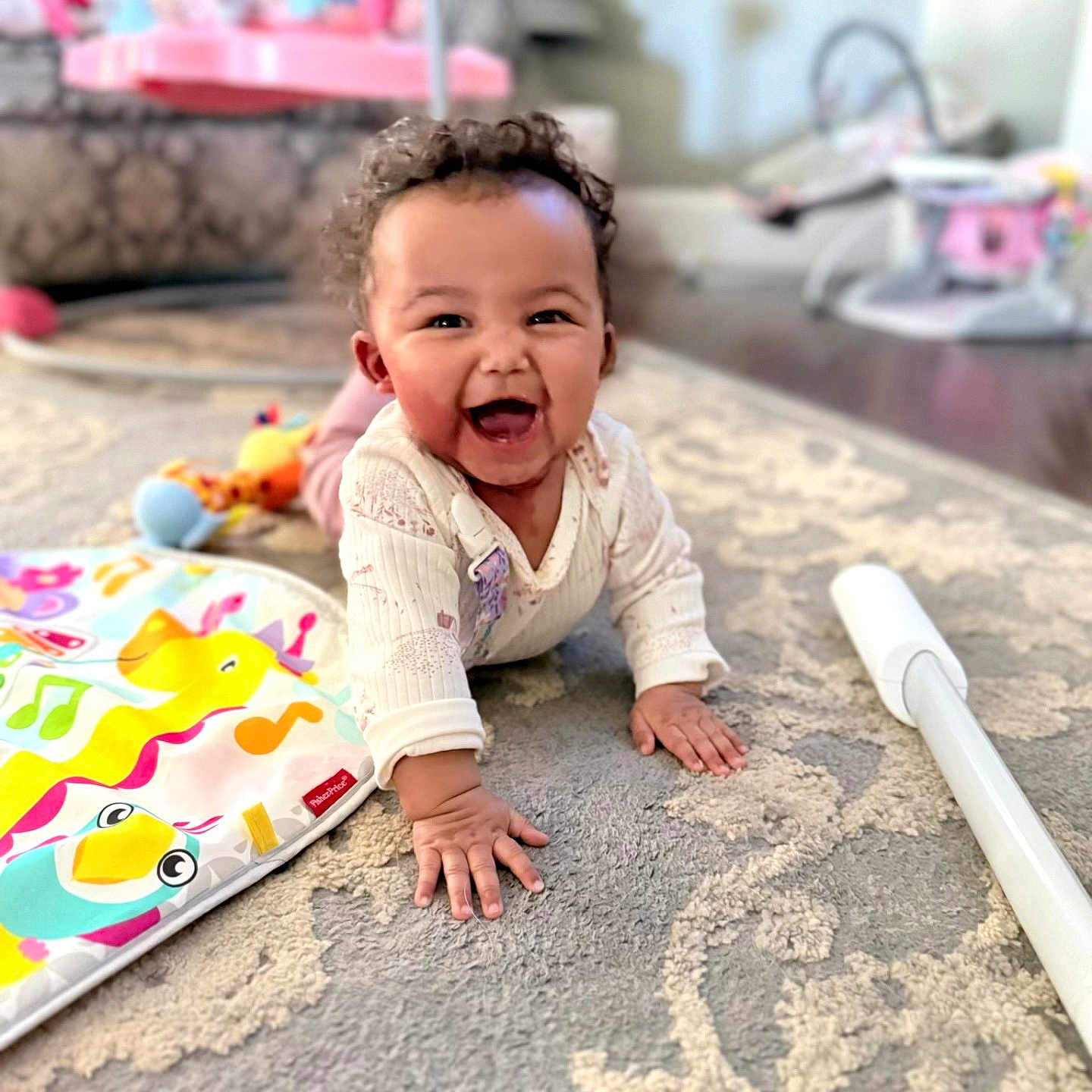 Ellieonna joined the competition — help win amazing prizes! baby, child, crawling, smiling, curly_hair, carpet, toy, colorful, pink, indoor, playful, happy, infant, person, home, sleeve, furniture, blurred_background, floor, cute