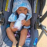 baby, child, stroller, bottle, hat, sunhat, blue, white, clothing, footwear, barefoot, seatbelt, outdoor, sunlight, infant, person, cute, smiling, summer, playtex