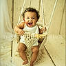 Ellieonna joined the competition — help win amazing prizes! baby, child, smiling, swing, macrame, curly_hair, white_outfit, wooden_floor, indoor, happy, portrait, cute, infant, playful, seated, decor, fabric, rope, light, warm_tones