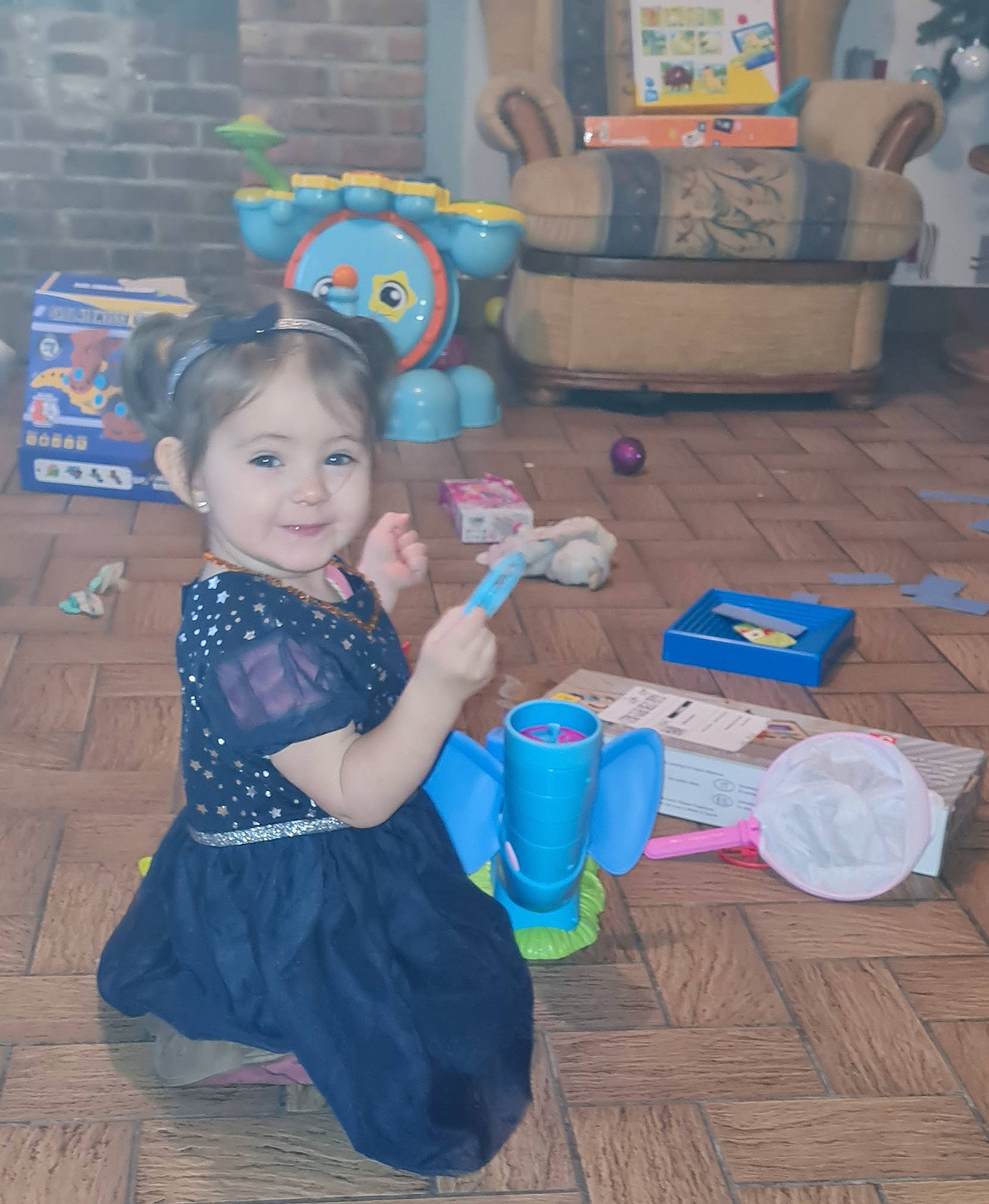 Mylianna participe au concours pour gagner de l'argent avec cette photo : blue, box, child, couch, event, floor, flooring, fun, happy, human, joy, leisure, person, purple, shipping_box, sitting, skin, smile, standing, textile